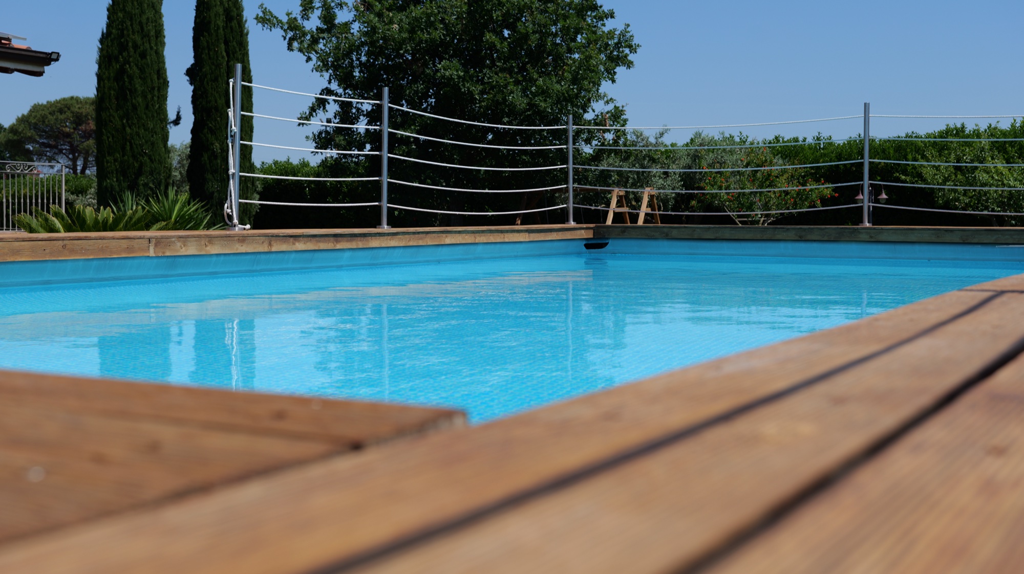Piscina privata con bordo in legno e acqua azzurra